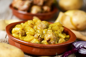 spanish guiso de patatas con albondigas, a stew with potatotes a