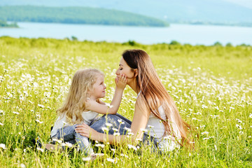 mother and daughter in field of daisies