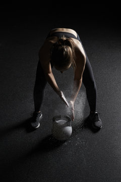 Woman preparing to lift kettlebell in a gym