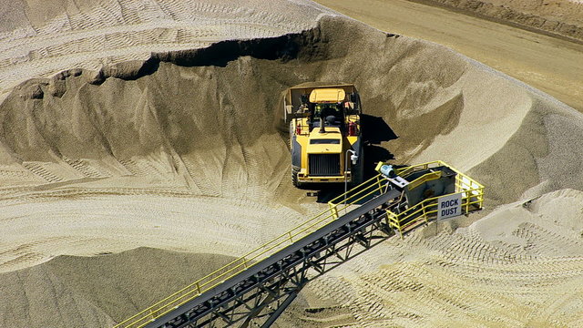 Aerial shot tractor working at rock quarry, zoom ou