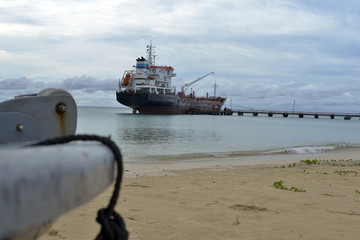 oil tanker vessel at dock with boat bow in foreground  anchor pu