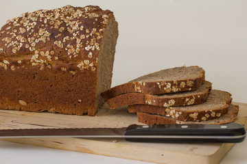 Brotscheiben und Brotlaib auf Holzbrett, Dinkelbrot, nah