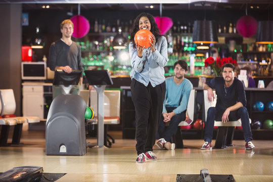 Cheerful young woman goes bowling with her friends