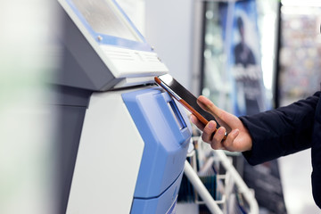 Obraz premium Woman connecting cellphone and ticketing machine