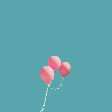 Three pink balloons against blue sky