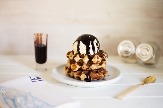 Close-up of a stack of Waffles with vanilla ice cream and chocolate sauce