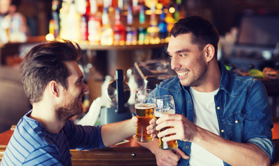 happy male friends drinking beer at bar or pub