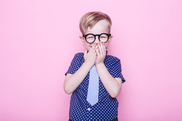 Little adorable kid in tie and glasses. School. Preschool. Fashion. Studio portrait over pink...