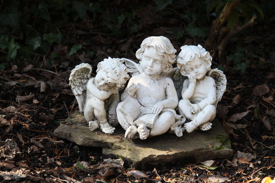 Drei Engel sitzen auf einem Grab