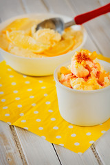 Vanilla ice cream with lemon peel on an old wooden table