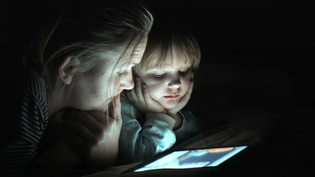 Mather and daughter enjoying a movie on tablet 