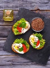 Healthy sandwich with mozzarella, tomato, eggs and flax-seed