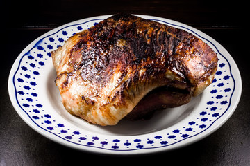 roasted pork ham in a dish on dark flat stone ambient 