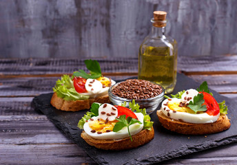 Healthy sandwich with mozzarella, tomato, eggs and flax-seed