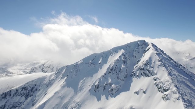 Aerial Flight Over Around Snowy Peak Beautiful Blue Sky Clouds Epic Adventure Journey Concept UHD 4K