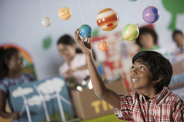 A boy looking up at a display of the planets, a presentation of the planetary system, 