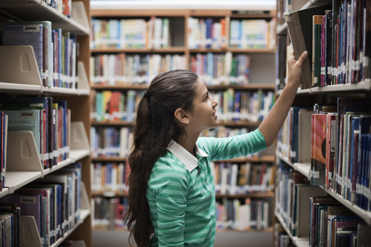 A girl looking at books in a library,