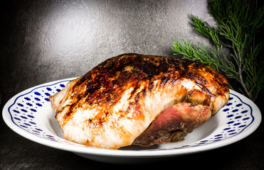 roasted pork ham in a dish on dark flat stone ambient 