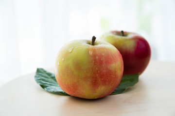 apples with green leaves isolated on light background
