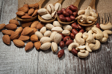 Healthy mix nuts on wooden background. Almonds, hazelnuts, cashews, peanuts, brazilian nuts