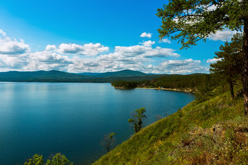 Fototapeta na wymiar Russia. Southern Urals. Lake Turgoyak. The view from the hill over the lake in clear weather in the summer. 