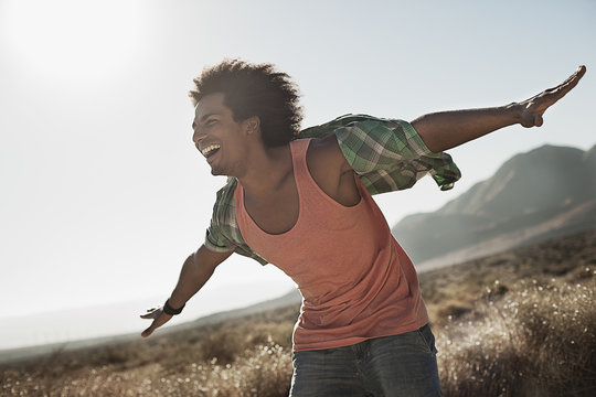A man with arms outstretched in a gesture of freedom and excitement, leaning into the breeze balancing,