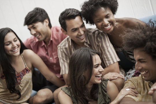 Six young people, three men and three women, laughing, 