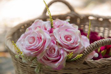 Many fake pink roses in a basket