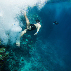 Underwater shoot of a young man jumping in a red sea