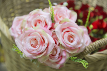 Many fake pink roses in a basket