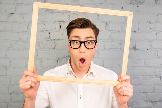 Shocked man in glasses grimacing with open mouth inside fraime