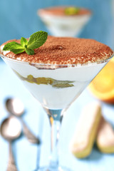 Italian dessert tiramisu with orange in a glass.