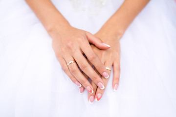 Hands of the bride in white dress