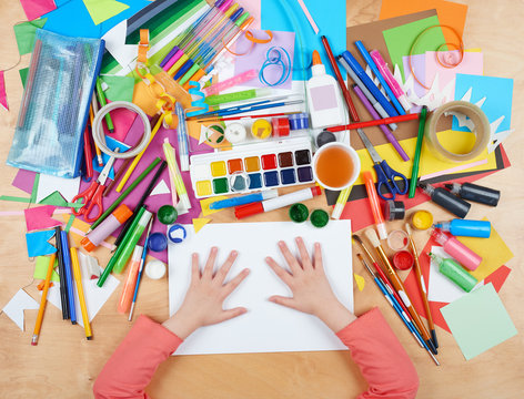 Child drawing top view. Artwork workplace with creative accessories. Flat lay art tools for painting.