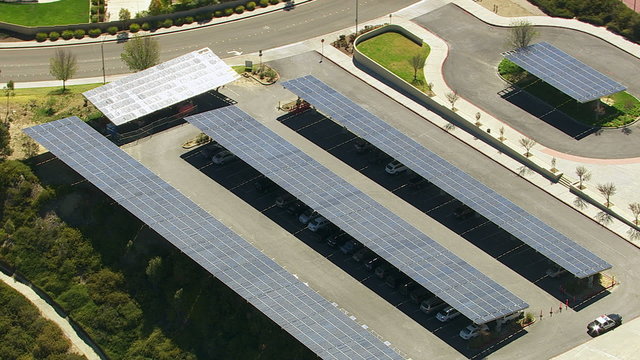 Aerial shot of solar panels over cars in parking lot