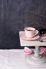 Coffee cup and cupcake dessert on vintage table. Copy space.