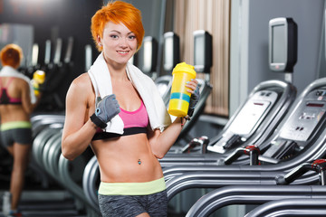 Cute fit girl with red short hair in gym