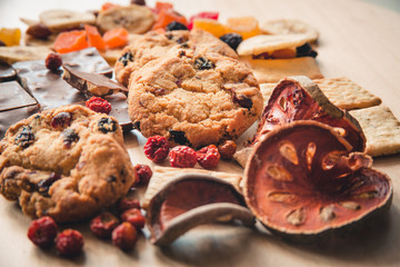 Cookies with chocolate are handmade. On the background of dried fruits and chocolate on wooden background