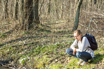 Fototapeta premium Young woman hiker in the spring forest, outdoors activities and leisure