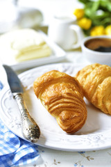 Croissant with butter,honey and cup of coffee.