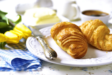 Croissant with butter,honey and cup of coffee.