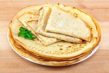 Pancakes in the plate on a wooden background