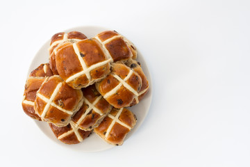 Freshly baked, Easter hot cross buns on an isolated white background.