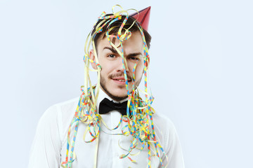 Attractive man posing on the white background with festal ribbons