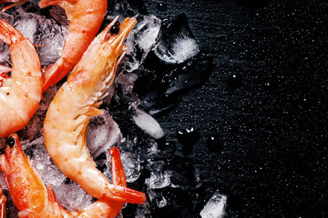 Obraz na płótnie Canvas Food background, frozen cooked shrimp with ice, black background