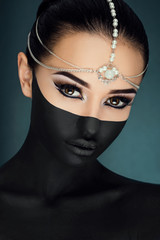 Beautiful brunette girl posing on the dark blue background