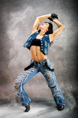 Young beautiful athletic woman in fashion jeans dancing modern style