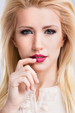 A portrait of beautiful blonde girl with red lips