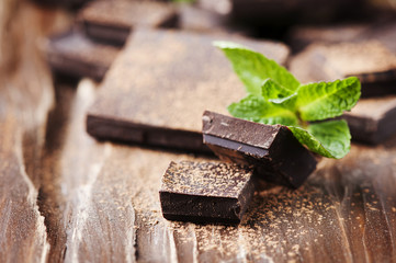 Dark chocolate and green mint on the wooden table