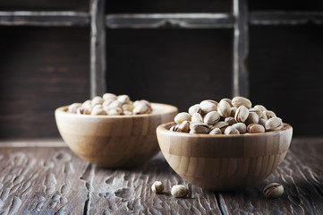 Salt pistachio nuts in the wooden bowl